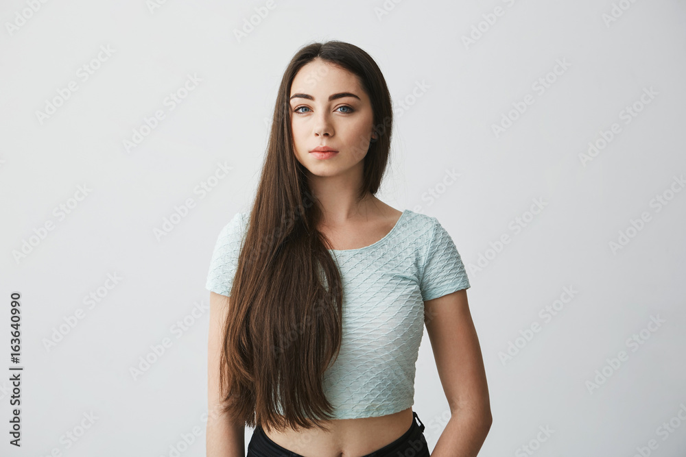 Portrait of beautiful brunette girl with natural makeup looking at camera over white background. Portrait of beautiful brunette girl with natural makeup looking at camera over white background.