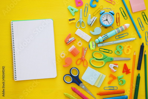Back to school concept. Top view. School notebook on yellow wooden background