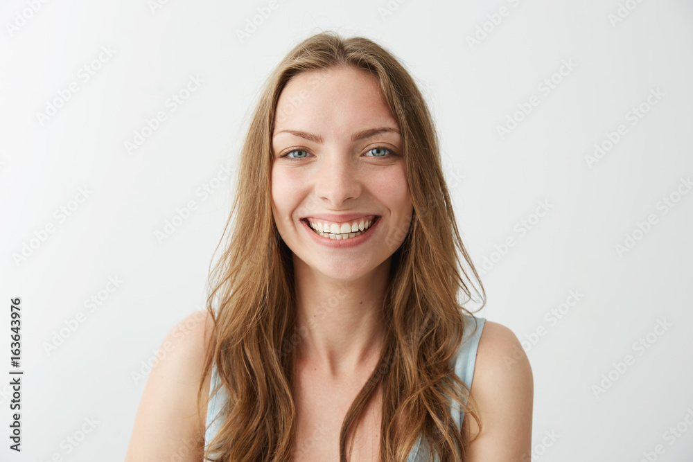 Beautiful sincere happy girl smiling laughing looking at camera over white background.
