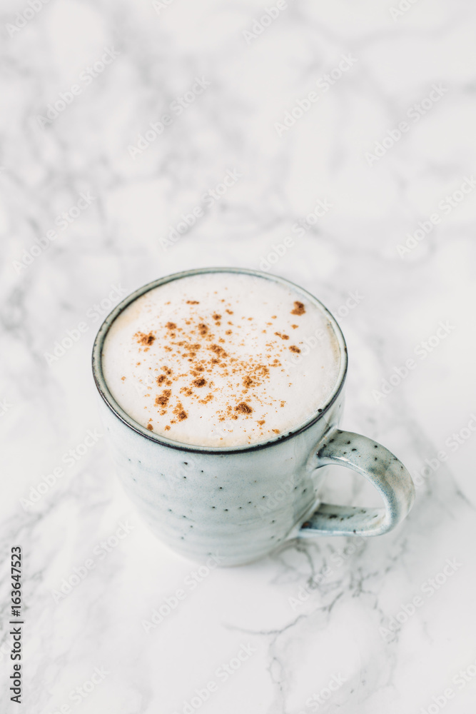 Cappuccino in a rustic style mug on a marble table Cappuccino in a rustic style mug on a marble table