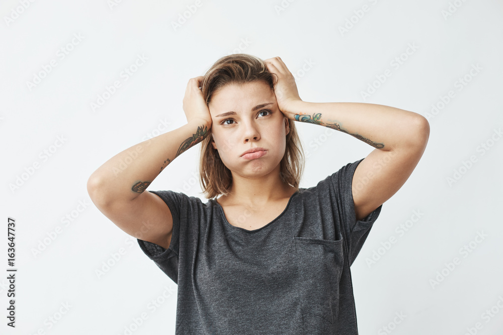 Young beautiful nervous upset girl thinking holding head over white background. Young beautiful nervous upset girl thinking holding head over white background.