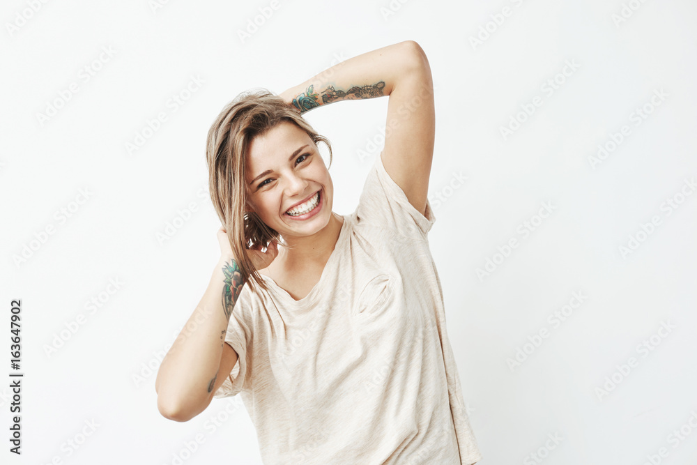 Portrait of young beautiful tattooed girl smiling posing looking at camera over white background. Portrait of young beautiful tattooed girl smiling posing looking at camera over white background.