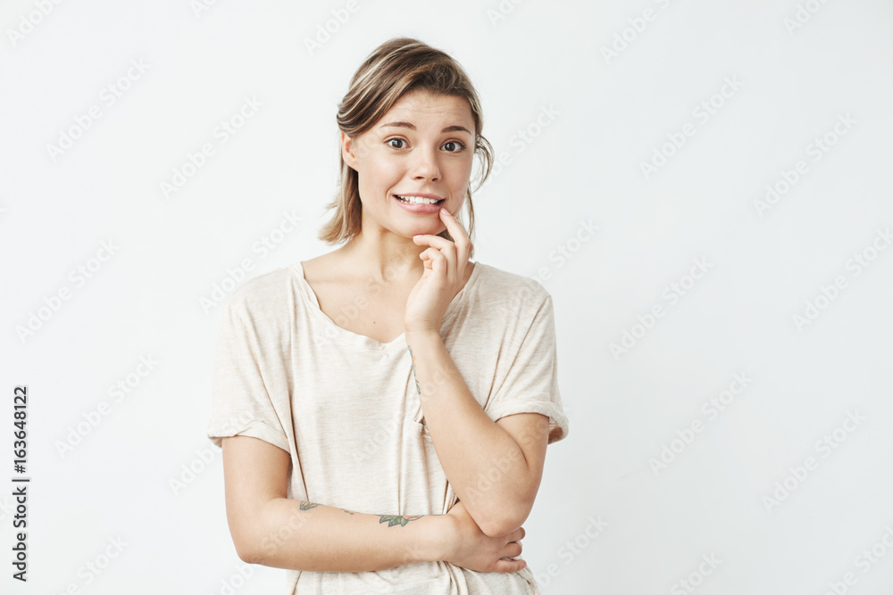 Young beautiful girl ashamed looking at camera over white background. Young beautiful girl ashamed looking at camera over white background.