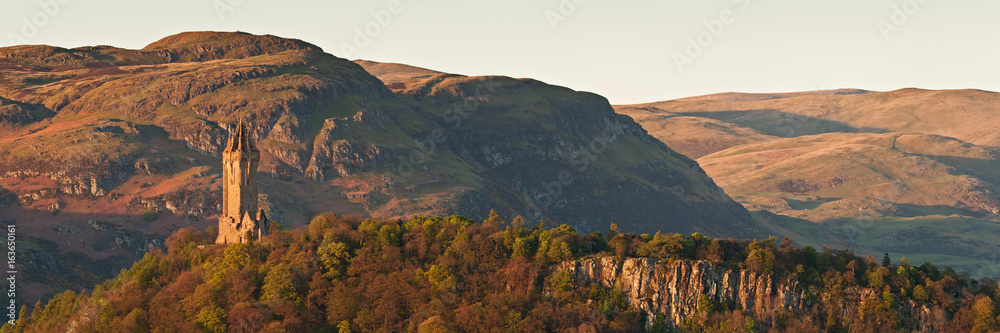 The National Wallace Monument standing on the top of Abbey Craig rock with the Ochil Hills at the background. Stirling, Scotland, UK