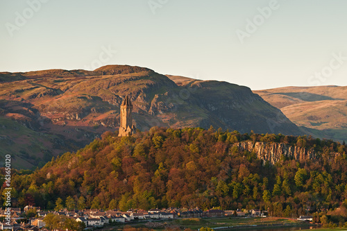 Foto The National Wallace Monument standing on the top of Abbey Craig rock with the Ochil Hills at the background