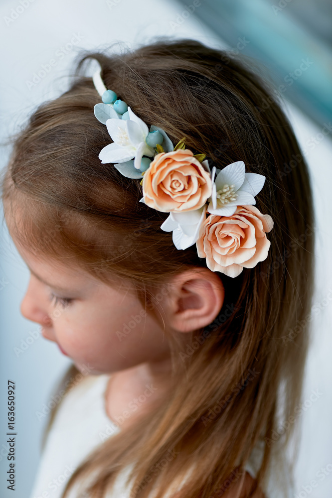Naklejka premium Charming girl with long ash-blond hair , lively blue eyes and a pinched nose, the bezel is handmade . Smiling, holding your hands up.Smiling and looking at camera