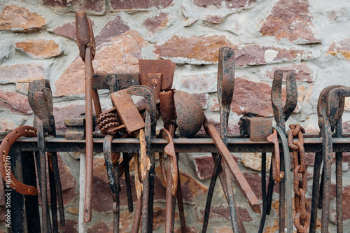 Old, rusty tools used for shoeing a horse displayed. photo