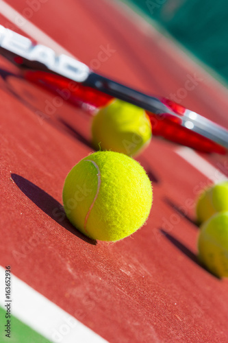 Tennis balls and racket on the grass court © fotofabrika