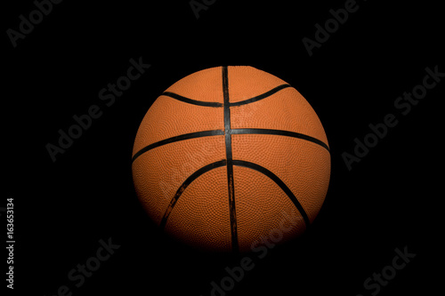 A single basketball isolated on a black background © Ben Gingell