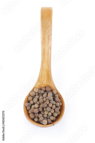 allspice in wooden spoon isolated