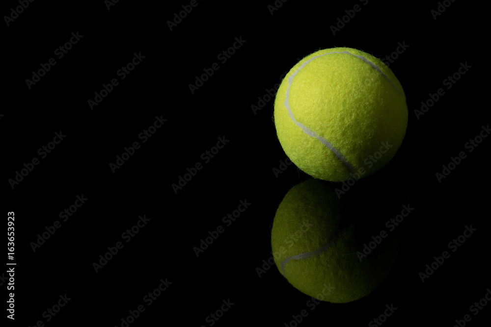 A single tennis ball isolated on a black background