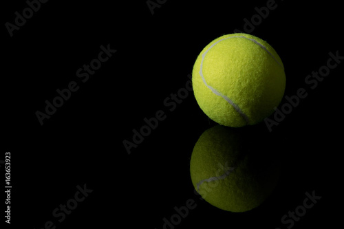A single tennis ball isolated on a black background © Ben Gingell