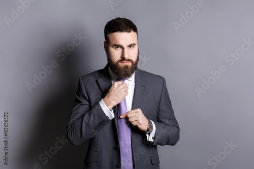 Handsome bearded businessman adjusting his tie