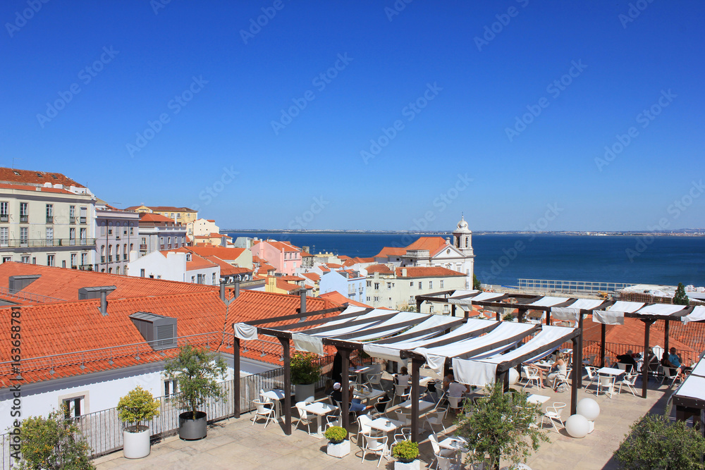 Panoramic Portas do Sol viewpoint and open air terrace cafe in Lisbon, Portugal. Rooftop view of Alfama old town historical district on summer time