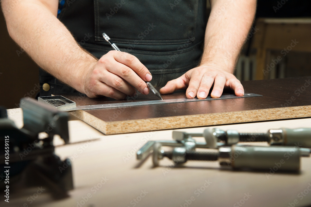Male hands draw a pencil on the ruler Male hands draw a pencil on the ruler