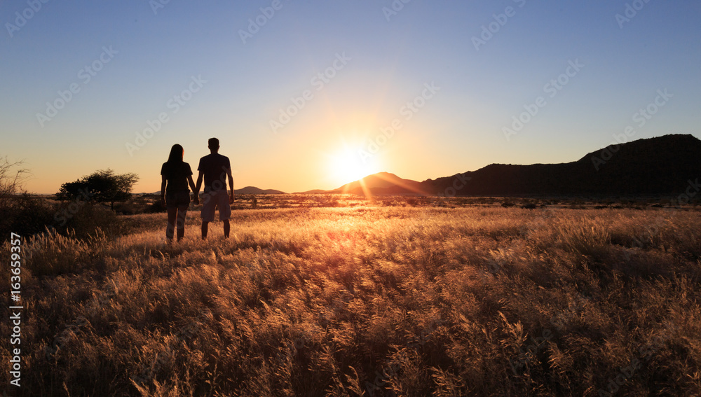 Couple at african savanna landscape. Namibia, South of Africa.