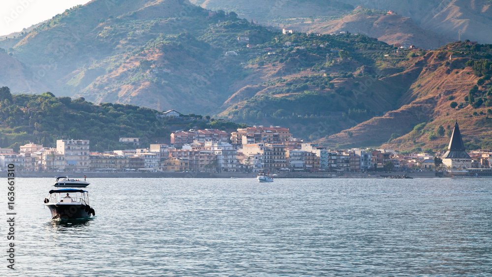 view of Giardini Naxos town in summer evening