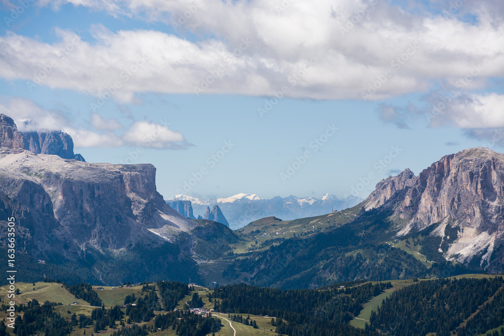 Dolomite mountain peaks with valley and cloudy sky, Italy