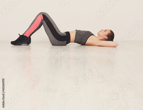 Fitness woman lay on floor at pilates training indoors