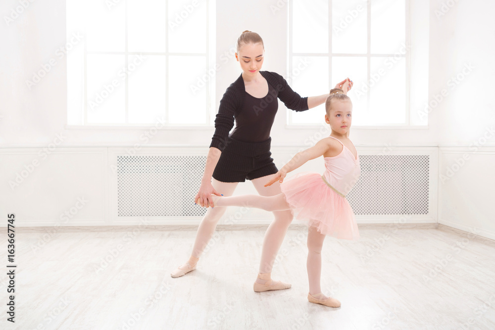 Fototapeta premium Little girl learn ballet with teacher copy space