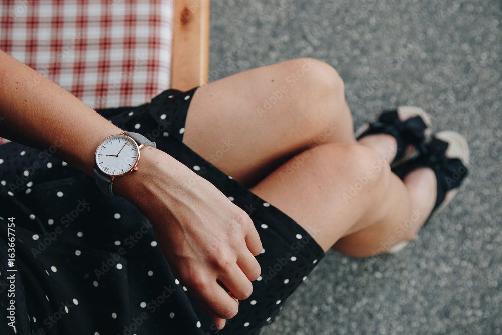 fashion details. woman wearing a black and white polka dot off dress. wearing a beautiful watch. ideal summer outfit accessories. european fashion blogger streetstyle.