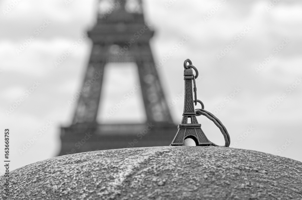 Eiffel tower keychain against real Eiffel tower