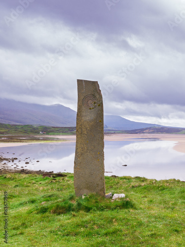 Standing stone with ancient Keltic symbols by the Kyle of Durness at Keoldale, near Durness, Sutherland, Scotland, UK photo