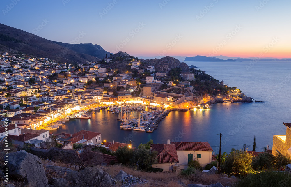 A view from above of Hydra island, Greece. City of Hydra and yacht marina at sunset