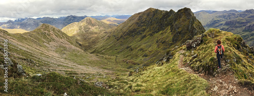 Woman admiring the notorious Aonach Eagach ridge in the Scottish Highland. Glencoe, Scotland, UK photo