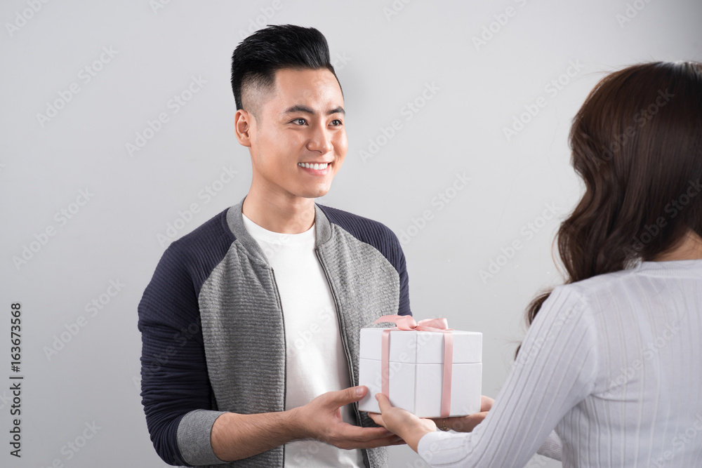 Happy smiling couple in love standing over gray background. Happy smiling couple in love standing over gray background.