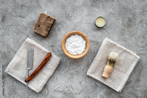 Preparing for men shaving. Shaving brush, razor, foam on grey stone table background top view