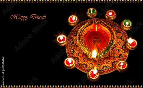 Diwali background content with decorations in diya and rangoli pattern.