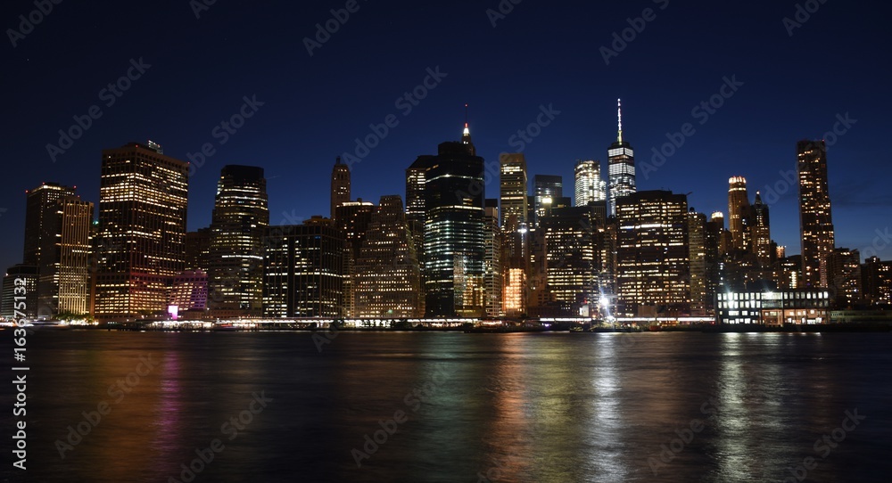 The Freedom Tower, Wall Street, and the skyline of downtown Manhattan from Brooklyn at sunset. The Freedom Tower, Wall Street, and the skyline of downtown Manhattan from Brooklyn at sunset.