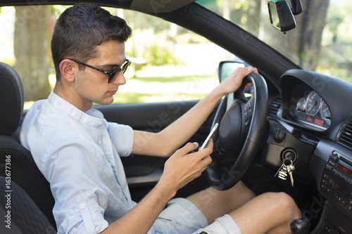 man driving looking at mobile phone