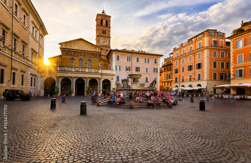 Naklejka premium Bazylika Santa Maria in Trastevere i Piazza di Santa Maria in Trastevere o zachodzie słońca, Rzym, Włochy. Trastevere to rione Rzymu, na zachodnim brzegu Tybru w Rzymie. Architektura i punkt orientacyjny Rzymu.