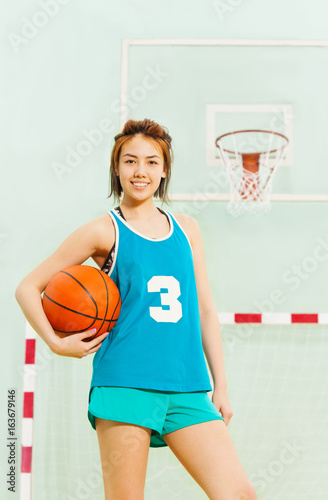 Teenage basketball player with ball under her arm © Sergey Novikov