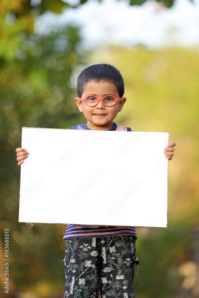 Indian child on eyeglass holding white board in hand Indian child on eyeglass holding white board in hand