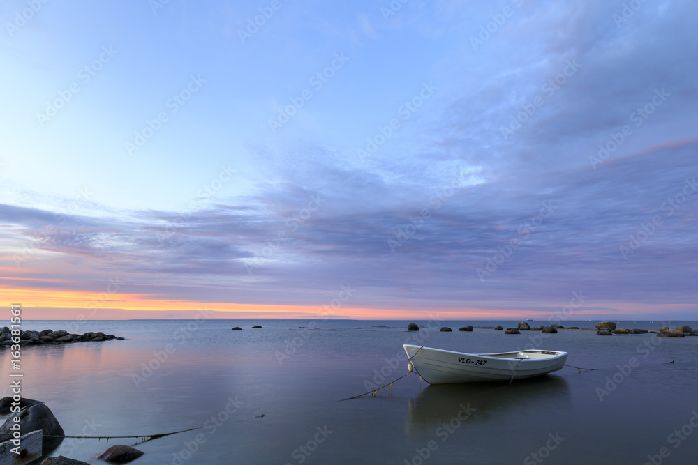 White boat in sea at sunset