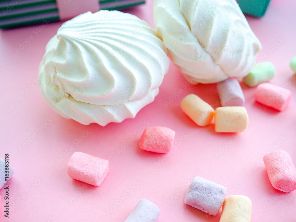 Colorful mini marshmallows background, close-up texture. A pile of different mini white, pink and orange puffy marshmallows. Marshmallow concept. Wallpaper for desktop. Selective focus.