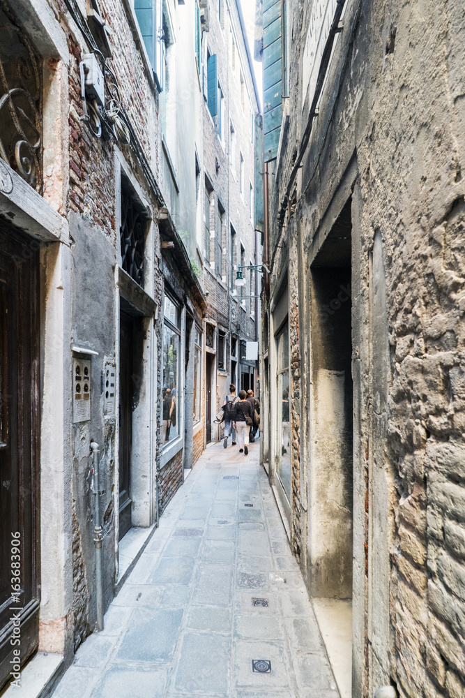 Narrow cobblestone alley in the oldest part of Venice, called 