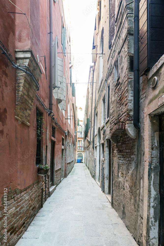Lonely cobblestone alley in the oldest part of Venice in Italy