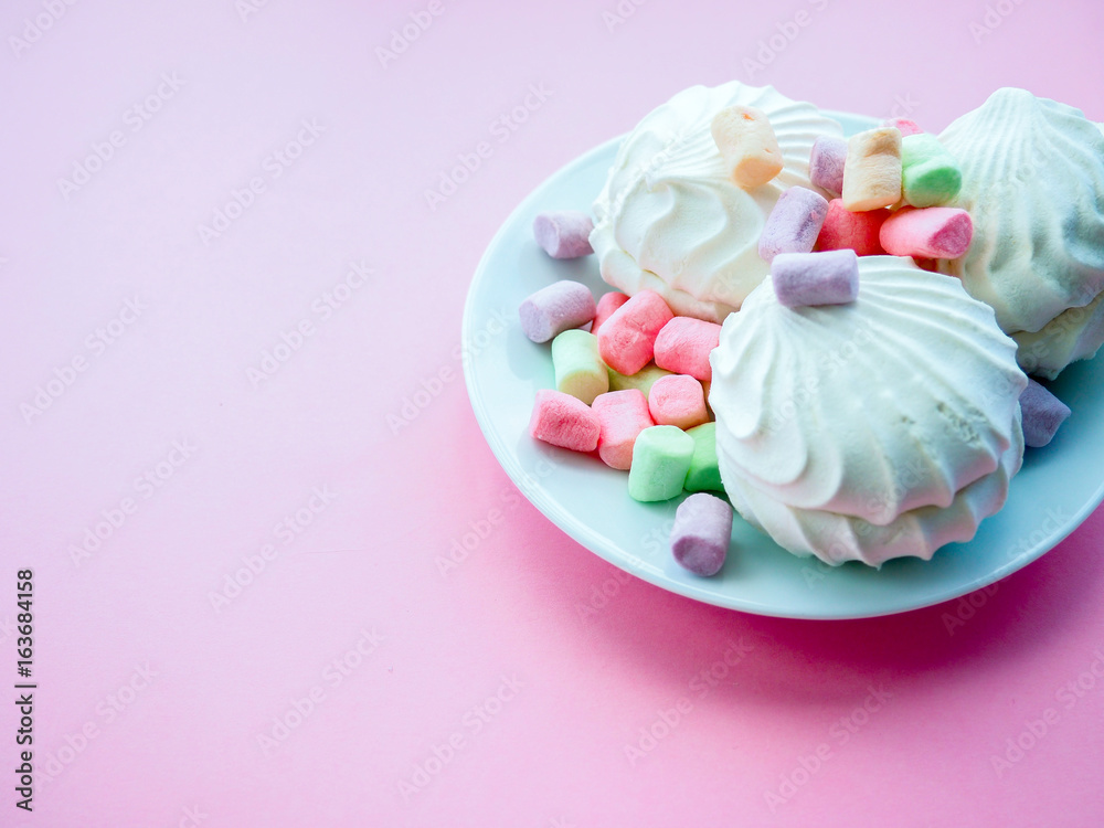 Marshmallow in white plate on pink background Marshmallow in white plate on pink background