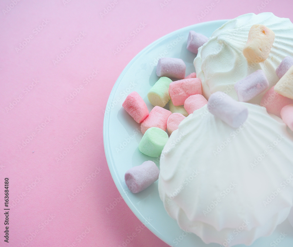 Marshmallow in white plate on pink background Marshmallow in white plate on pink background