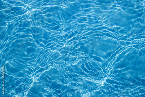 Background of clean water in a blue swimming pool