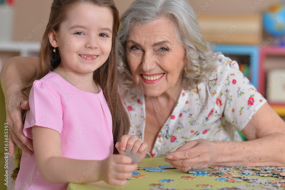 Fototapeta premium Grandmother collecting puzzle