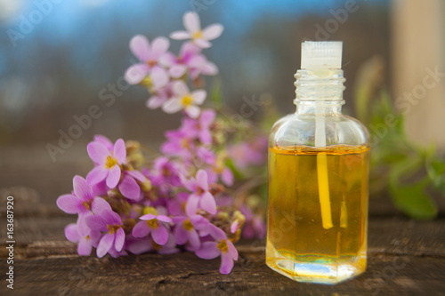 Essential oil of Arabis flower on a table in beautiful bottle