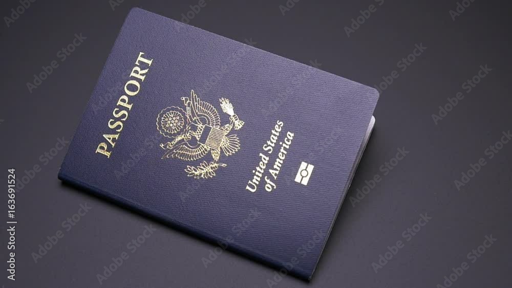 SINGLE UNITED STATES PASSPORT DROPS INTO FRAME IN SLOW MOTION SINGLE UNITED STATES PASSPORT DROPS INTO FRAME IN SLOW MOTION
