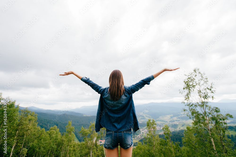 Woman in wild nature asking sky for blessing and enjoying nature greatness. Relaxation, meditation, harmony of inner life and mind. Unity of human and world. Exaltation of heart and consciousness. Woman in wild nature asking sky for blessing and enjoying nature greatness. Relaxation, meditation, harmony of inner life and mind. Unity of human and world. Exaltation of heart and consciousness.