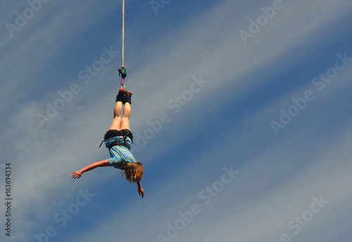 Woman doing Bungee Jump at end of Rope.