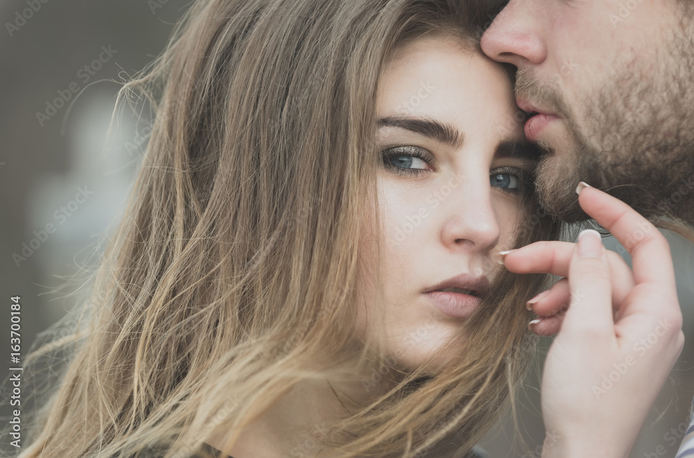 Φωτογραφία male lips touching adorable face of pretty girl